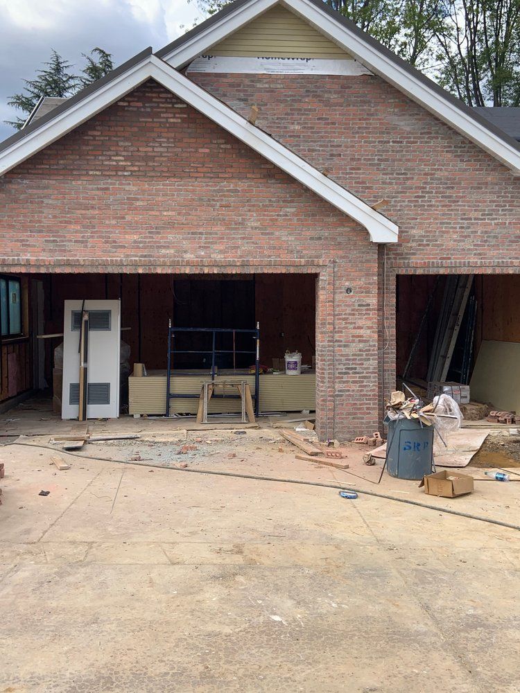 A brick house is being built with a large garage.