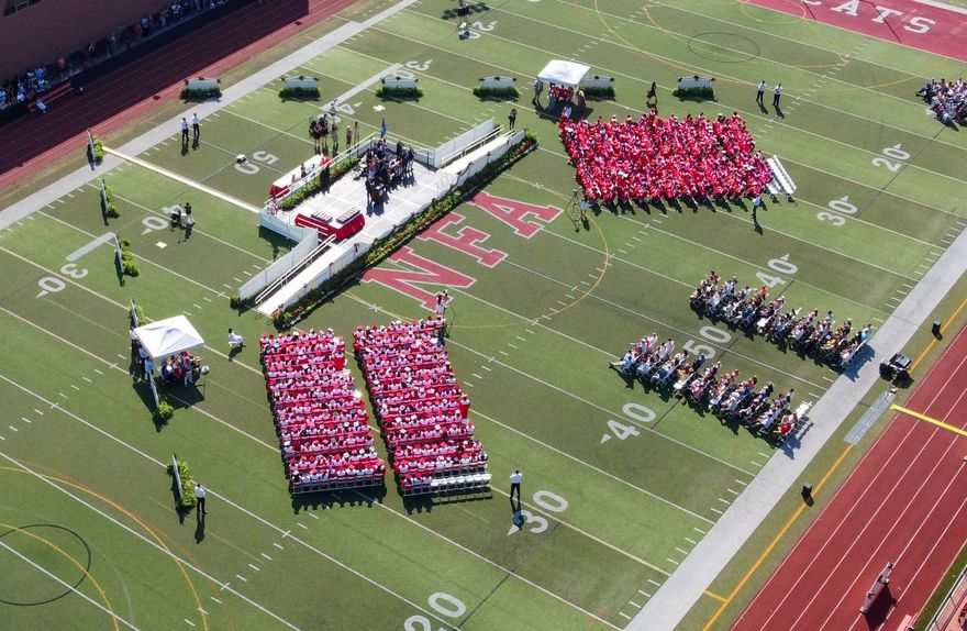 A large group of people are standing on a football field