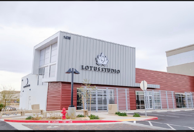 A lotus studio building with a fire hydrant in front of it.