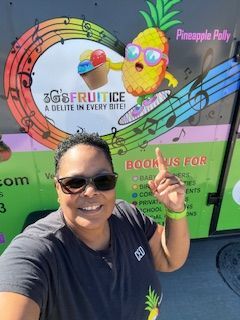 Woman pointing at a brightly decorated food truck with a cartoon pineapple mascot. 