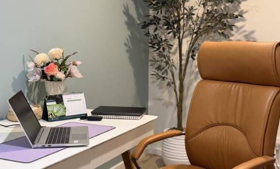 A woman is shaking hands with a man and woman in a living room.