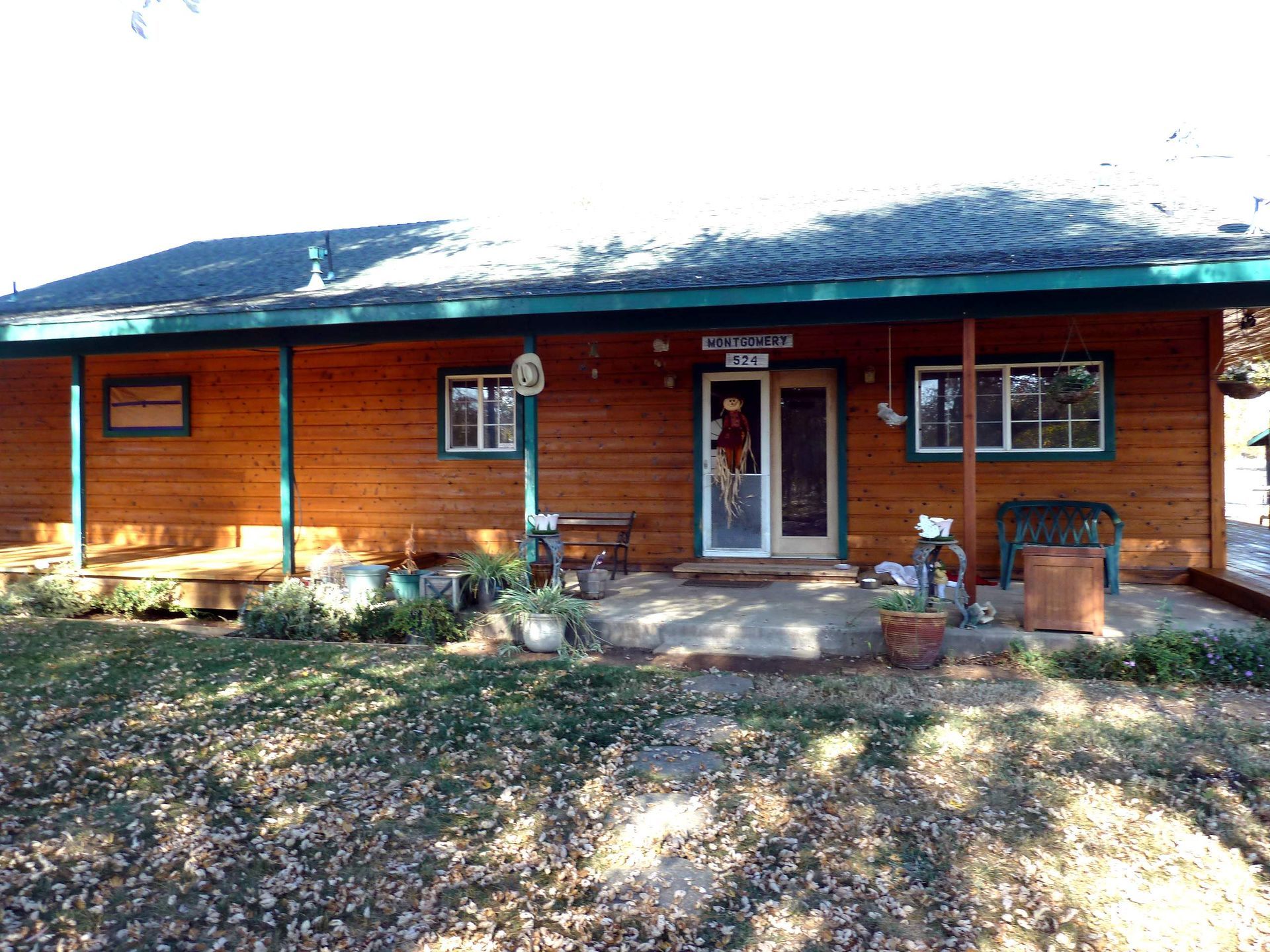 A single-story wooden house with a porch and several windows.