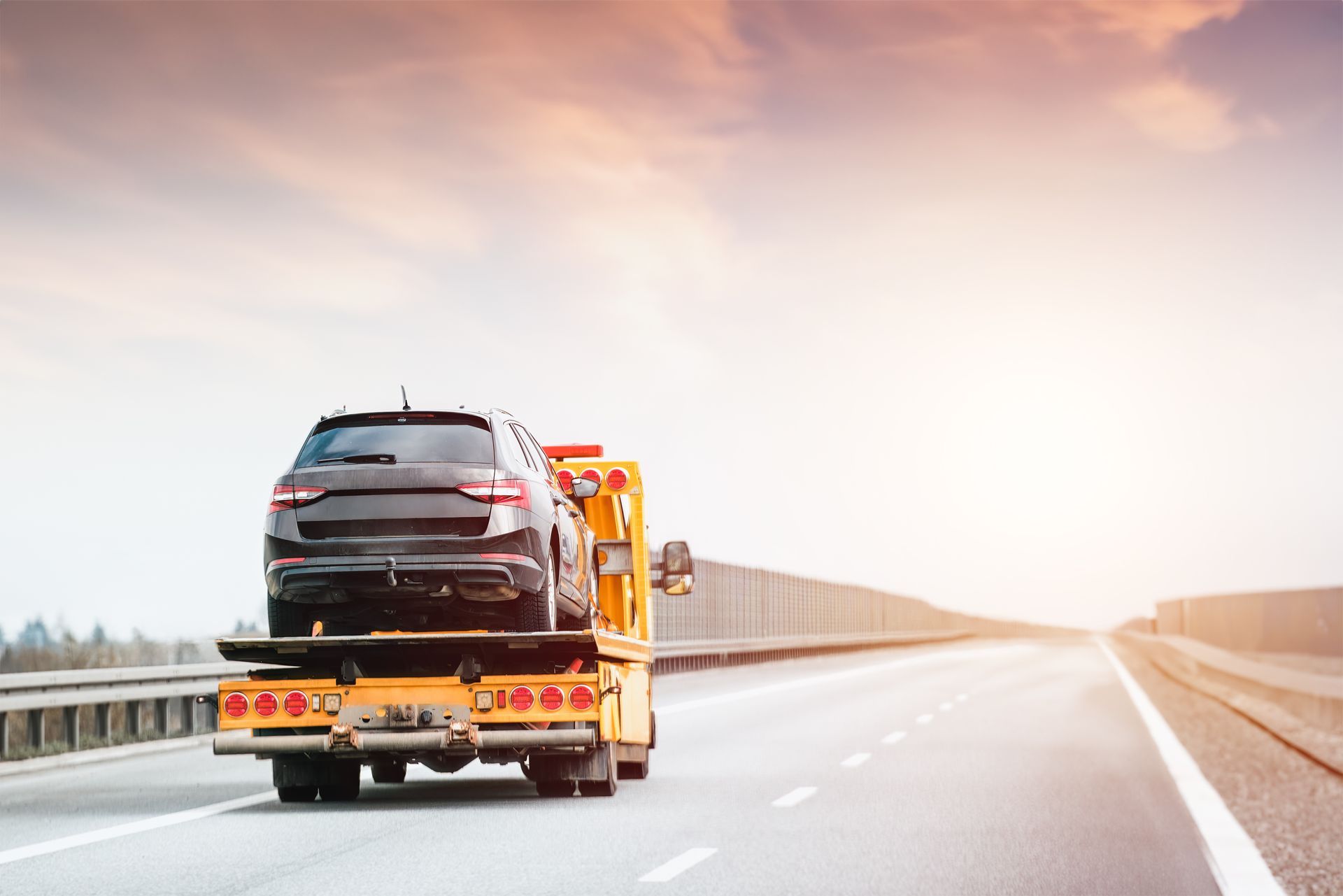 Tow truck at work. On an open road under the vast sky lies the silent tale of a car’s breakdown and the timely arrival of help. Tow truck at work. On an open road under the vast sky lies the silent tale of a car’s breakdown and the timely arrival of help.