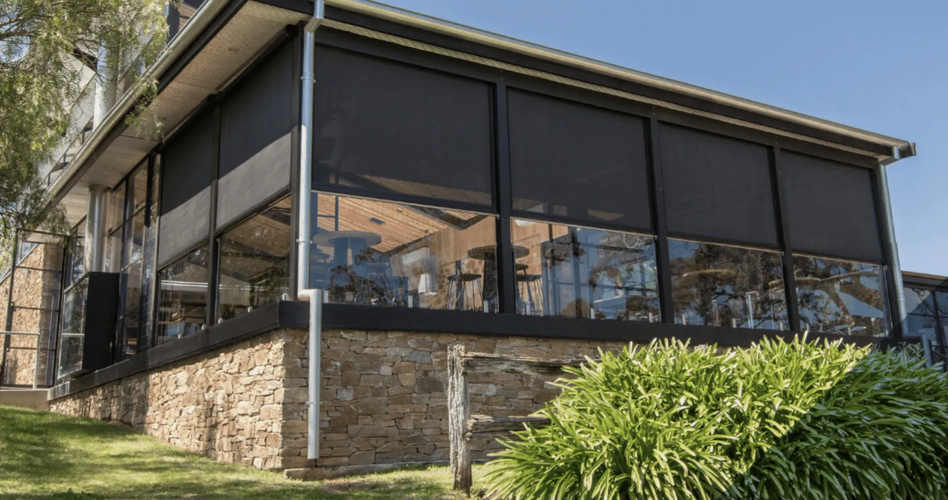 A Large Building With a Lot of Windows and a Screened in Porch — TT Shutters & Shading In Ballina, NSW