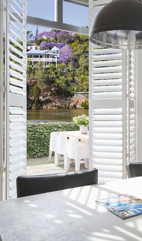 A Dining Room With White Shutters and a View of a River — TT Shutters & Shading In Kingscliff, NSW