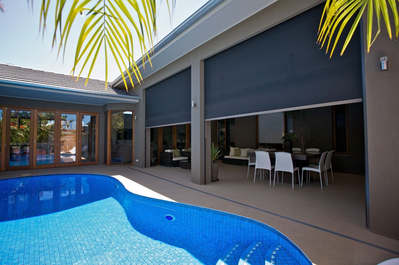 A House With A Swimming Pool And A Patio Area With Screen— TT Shutters & Shading In Ballina, NSW