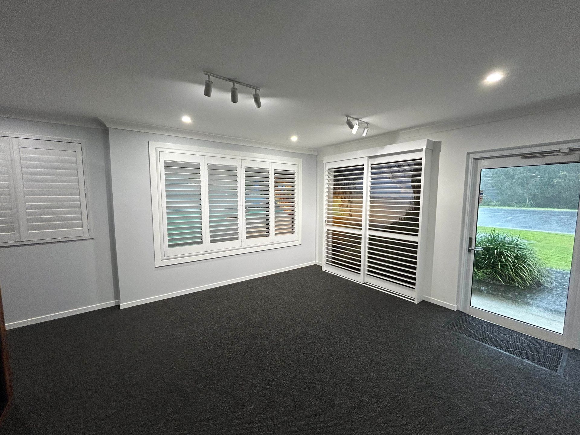 A Living Room With a Lot of Windows and Sliding Glass Doors — TT Shutters & Shading In Ballina, NSW