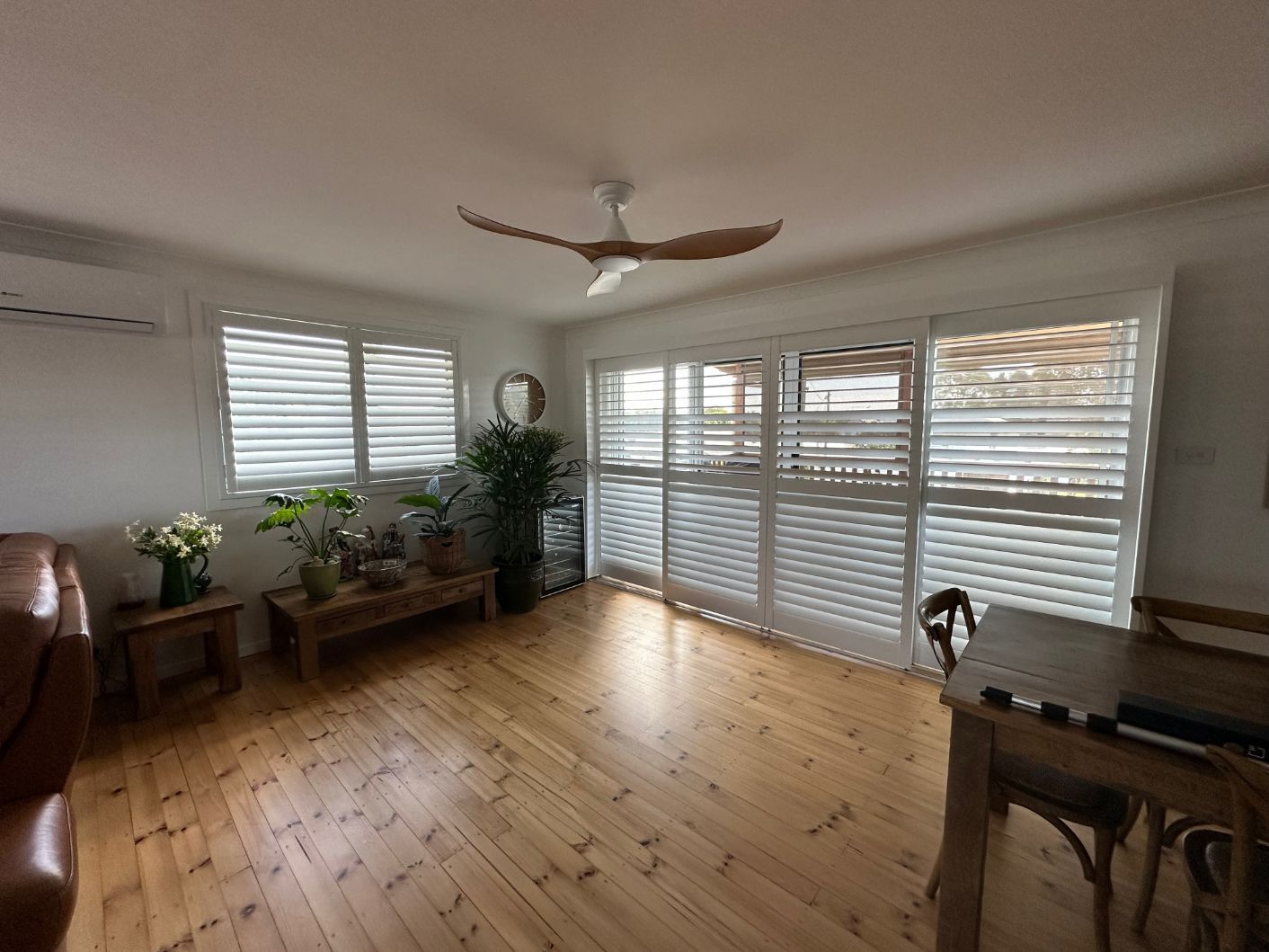 A Living Room With A Ceiling Fan, A Table And Chairs — TT Shutters & Shading In Ballina, NSW