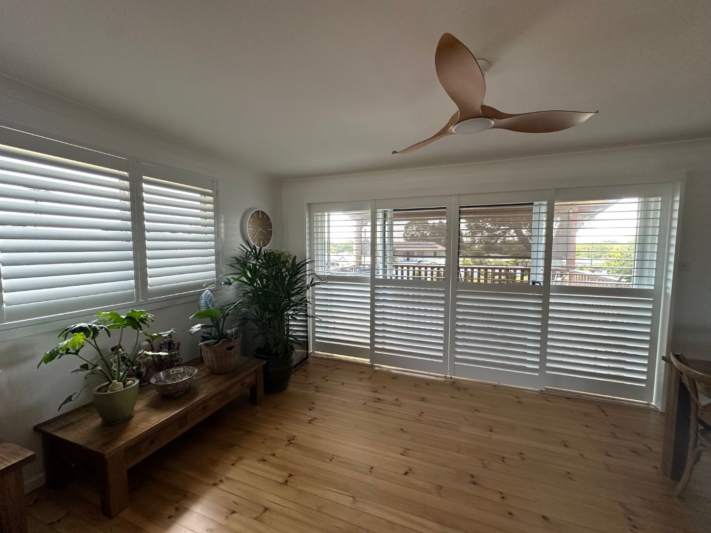 A Bedroom With a Bed, Sliding Glass Doors and Wooden Shutters — TT Shutters & Shading In Ballina, NSW