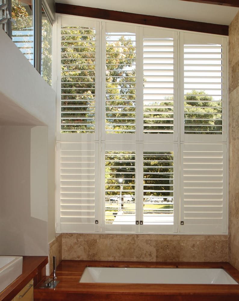 A Bathroom With Shutters on the Windows and a Bathtub — TT Shutters & Shading In Evans Head, NSW