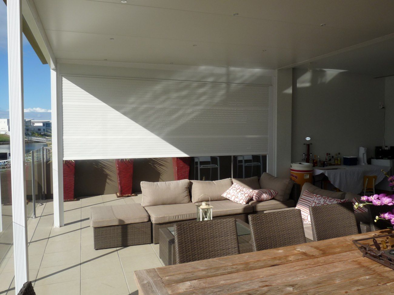 A Patio With Wicker Furniture And A Wooden Table — TT Shutters & Shading In Ballina, NSW