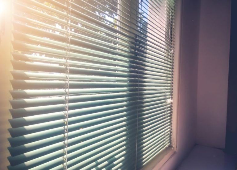 The Sun is Shining Through the Blinds of a Window — TT Shutters & Shading In Ballina, NSW