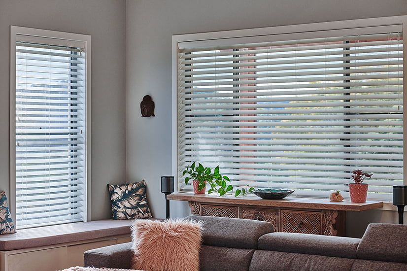 A Living Room With a Couch and a Window With Blinds — TT Shutters & Shading In Ballina, NSW