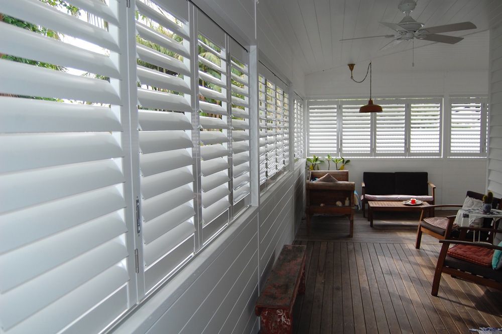 A Living Room With White Shutters on the Windows — TT Shutters & Shading In Ballina, NSW
