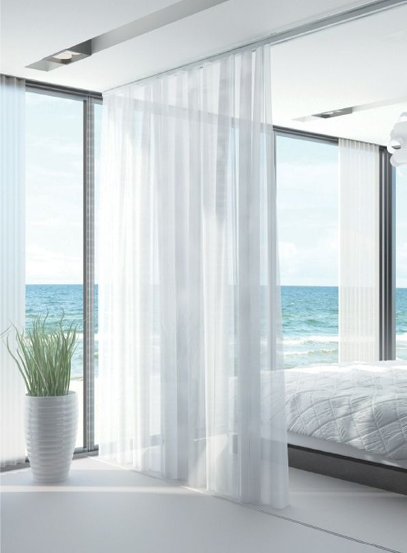 A Bedroom With White Curtains And A View Of The Ocean— TT Shutters & Shading In Ballina, NSW