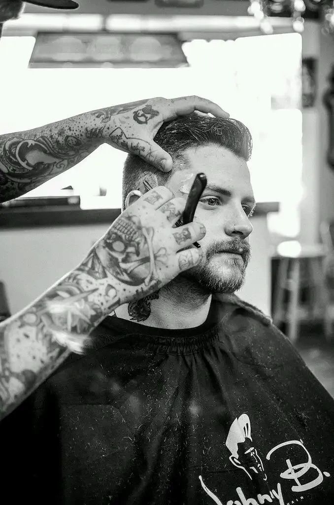 A Man Is Getting His Hair Cut By A Barber In A Black And White Photo — Get It Off Men's Barber Shop In Raymond Terrace, NSW