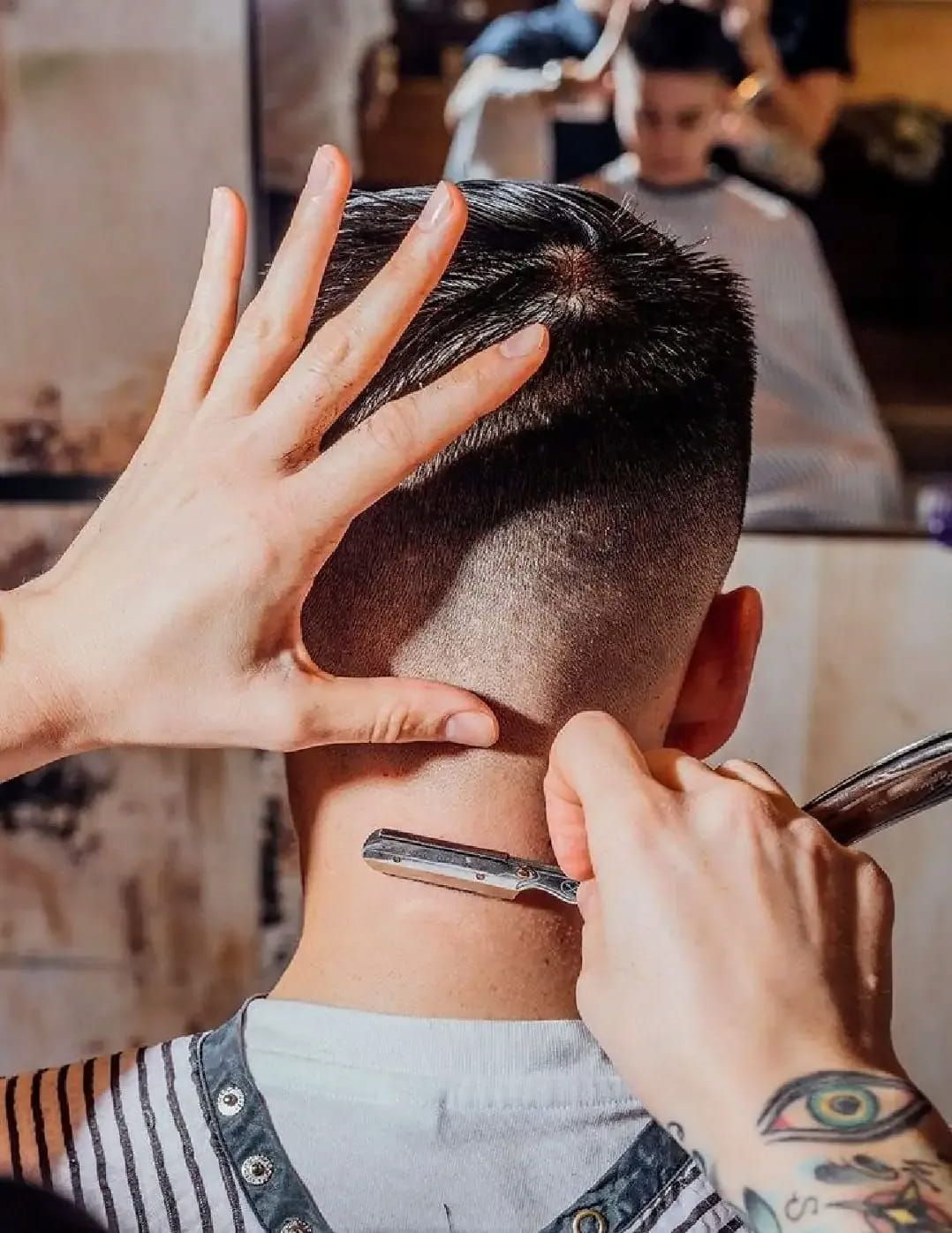 A Man Is Getting His Hair Cut By A Barber With A Razor — Get It Off Men's Barber Shop In Raymond Terrace, NSW