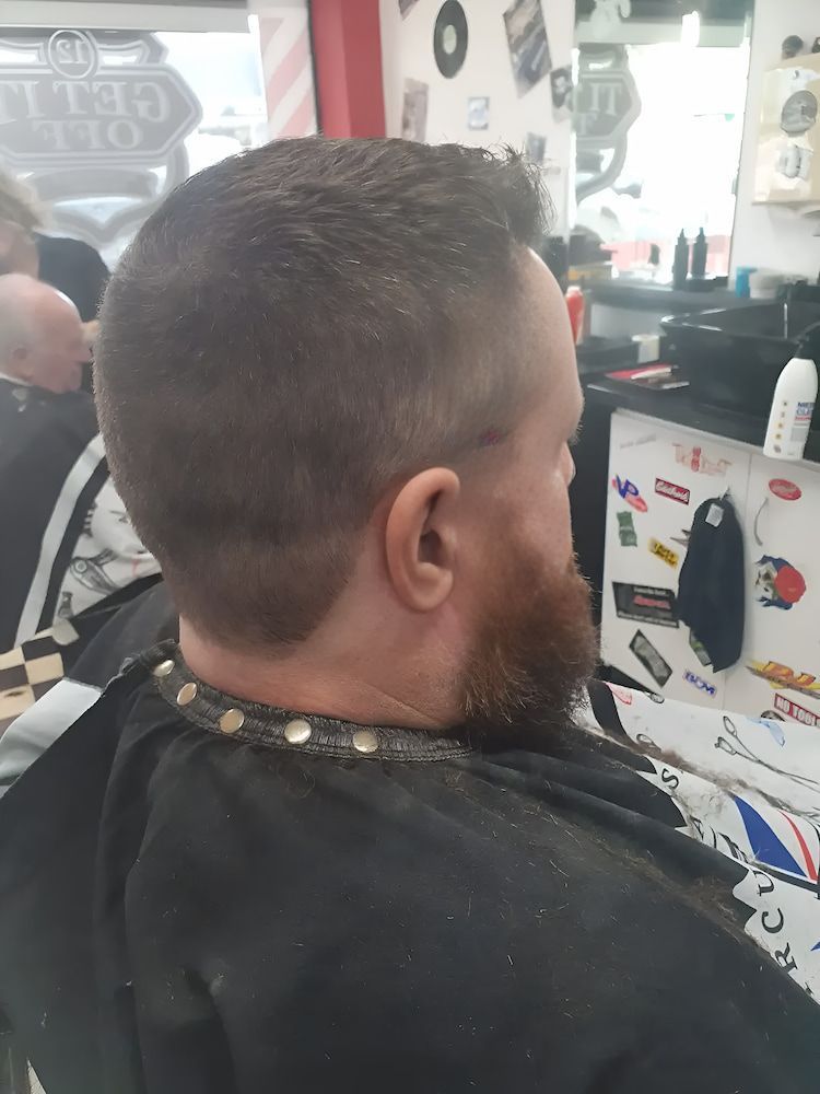 A Man With A Beard Is Getting His Hair Cut At A Barber Shop — Get It Off Men's Barber Shop In Raymond Terrace, NSW