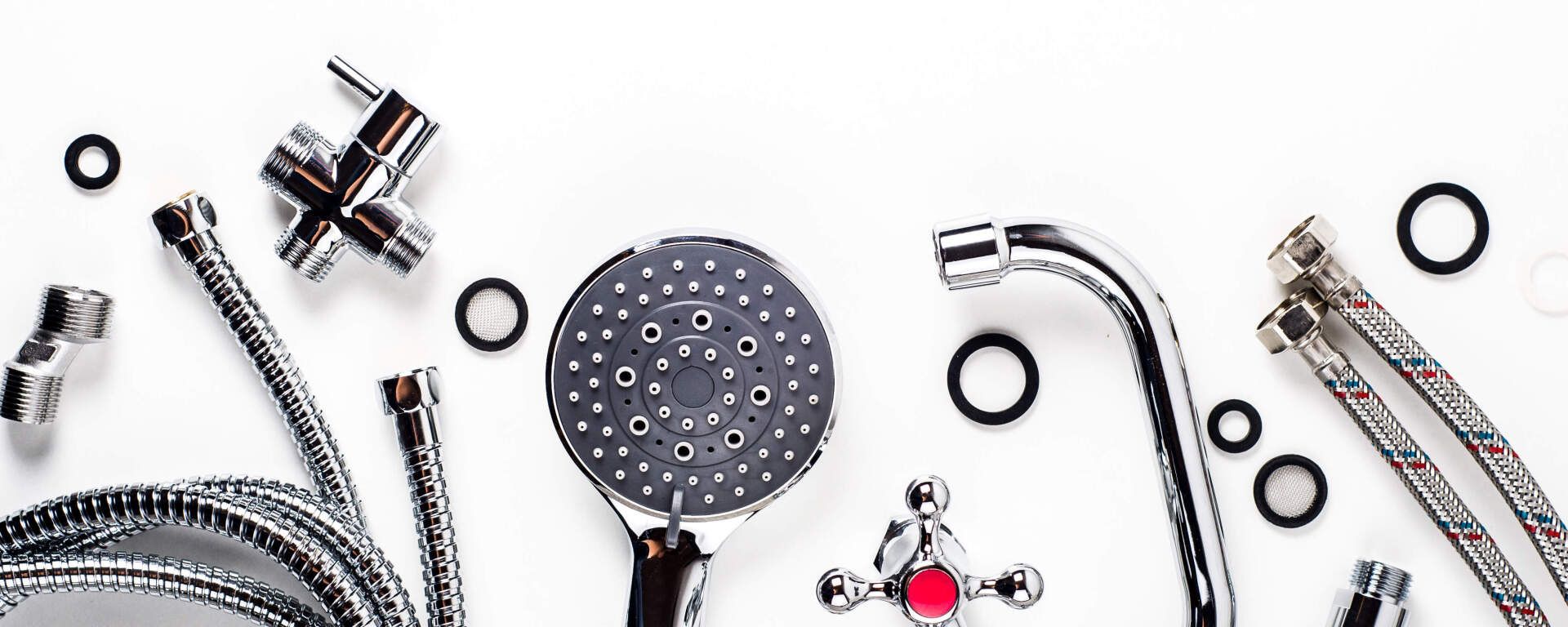 Assortment of chrome plumbing fixtures and black rubber rings on a white background.