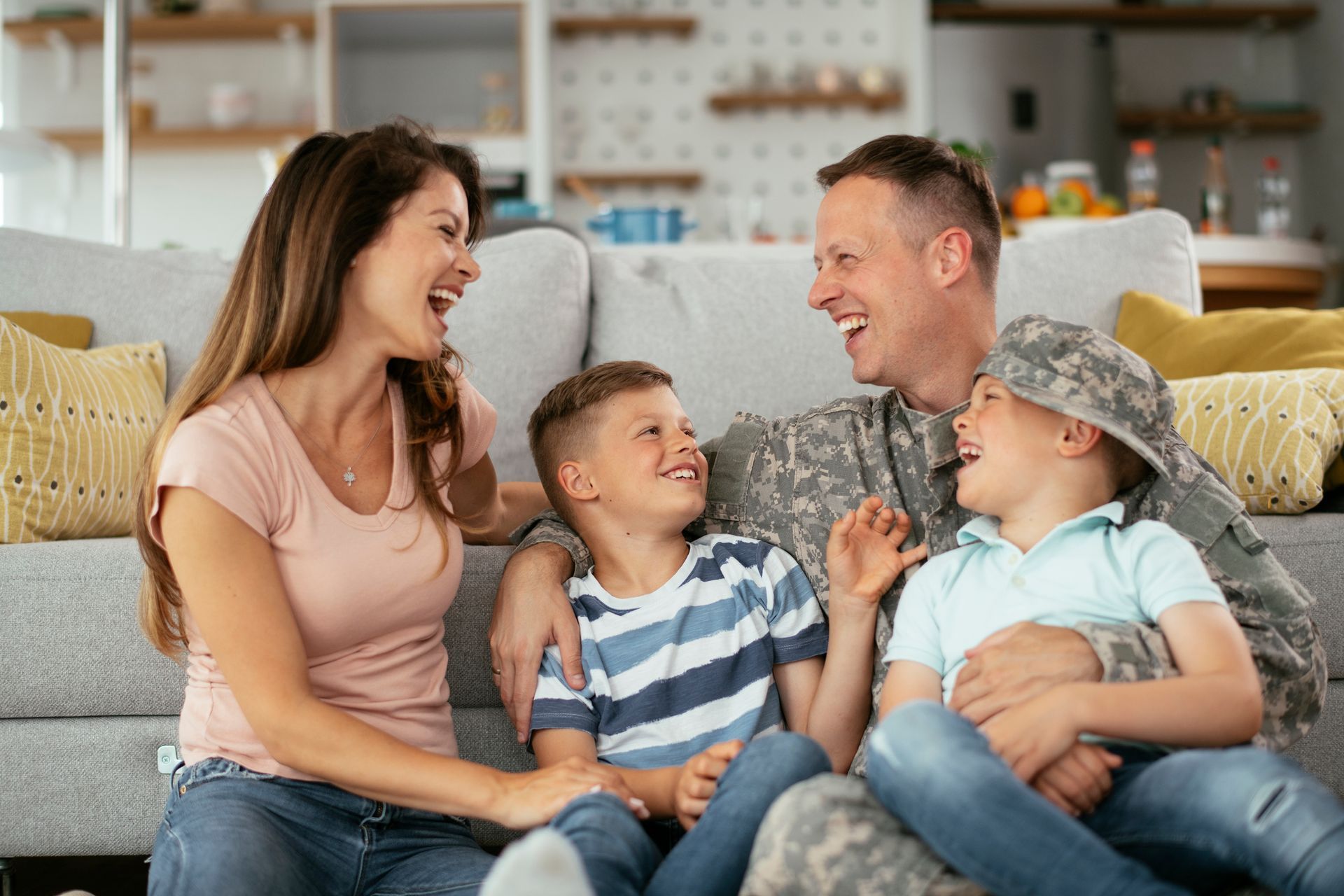 A soldier is sitting on a couch with his family.