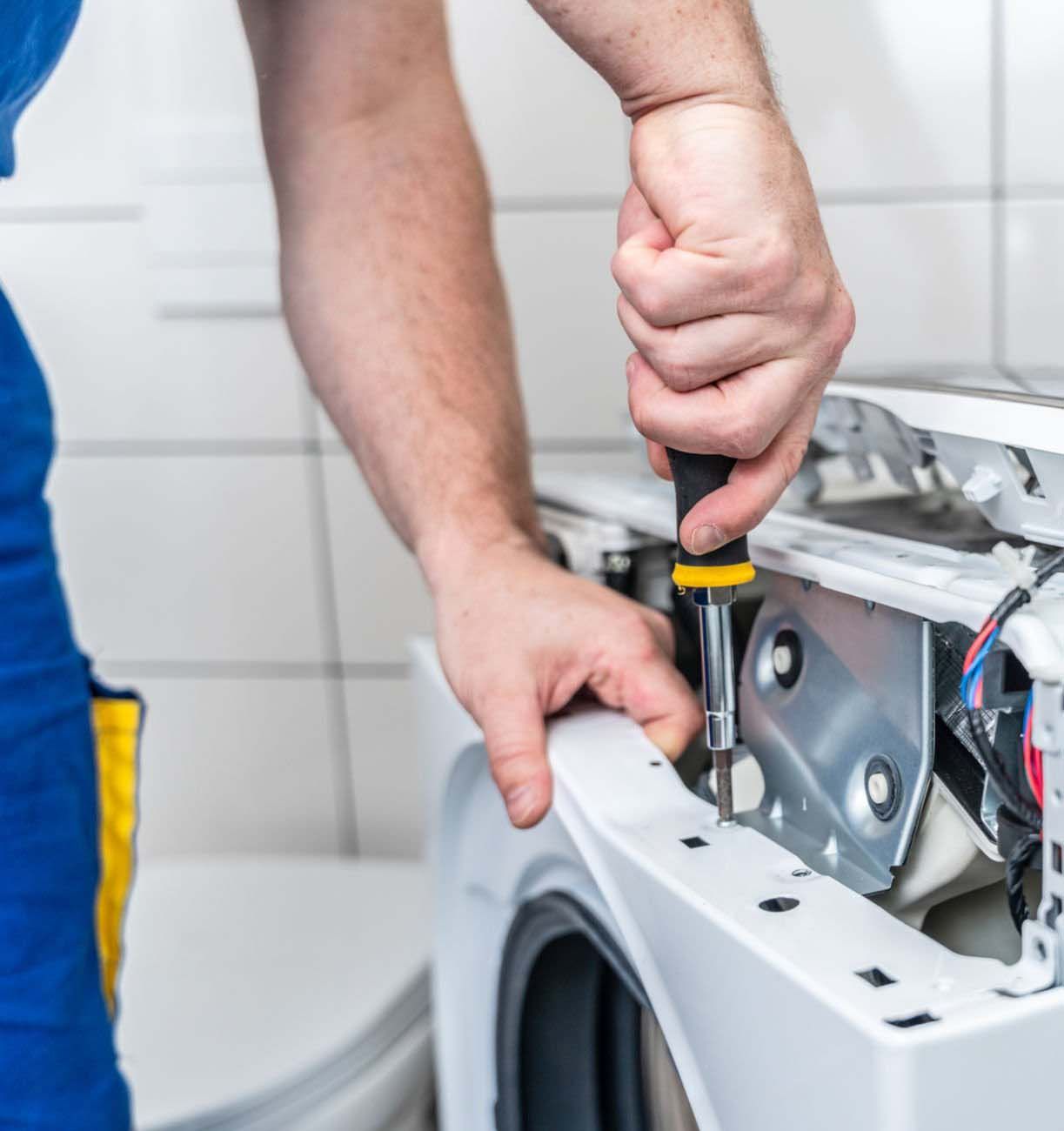 Woman in straw hat smiles, holding wine glass near a lake.