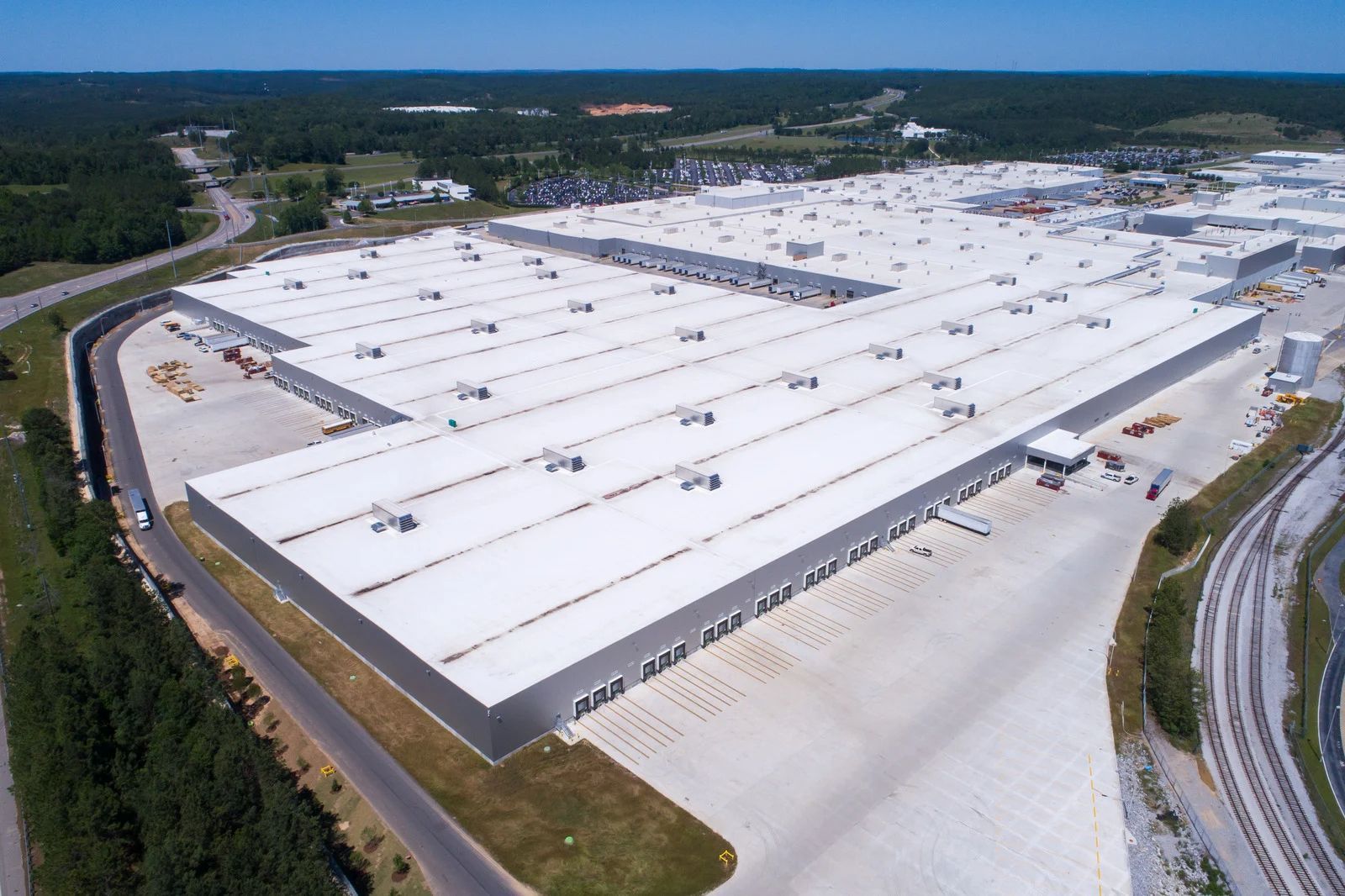 An aerial view of a large warehouse with a white roof