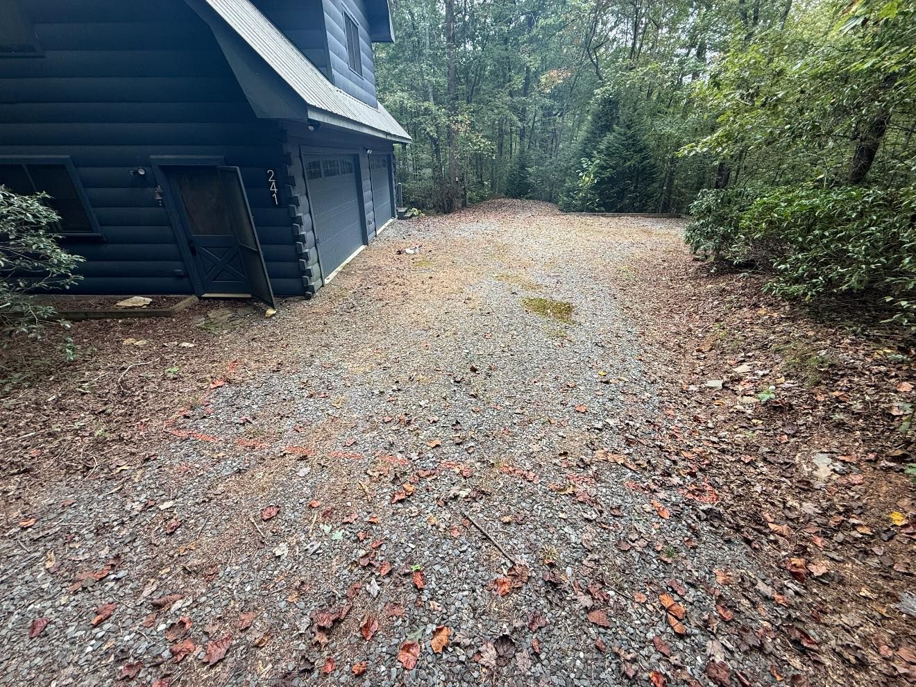 A wooden deck with stairs leading up to a lush green yard.