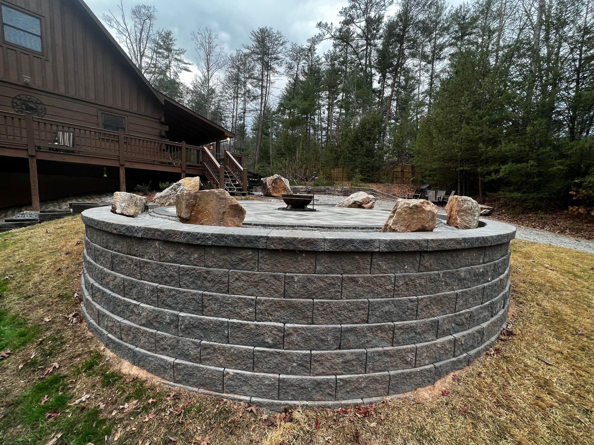 there is a fire pit in the middle of the yard in front of a house .