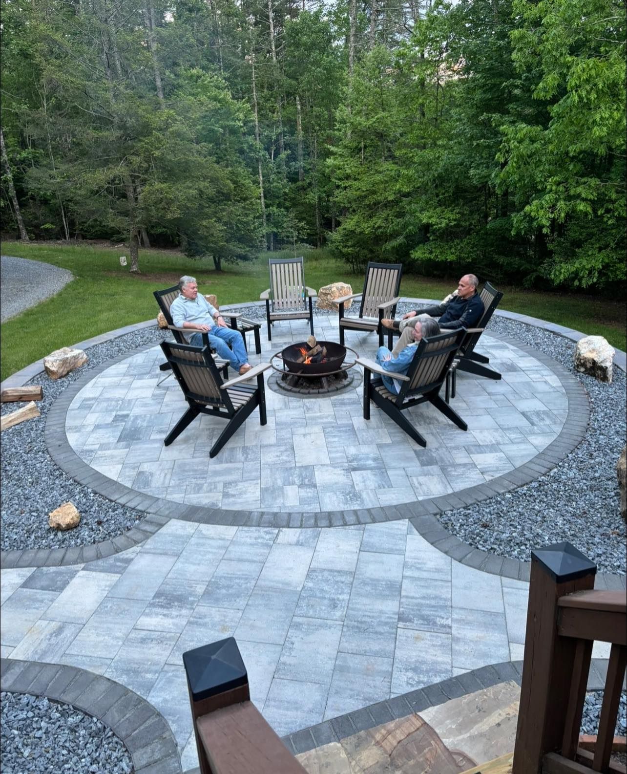 Outdoor living space with fire pit, grill, seating, and paver patio.