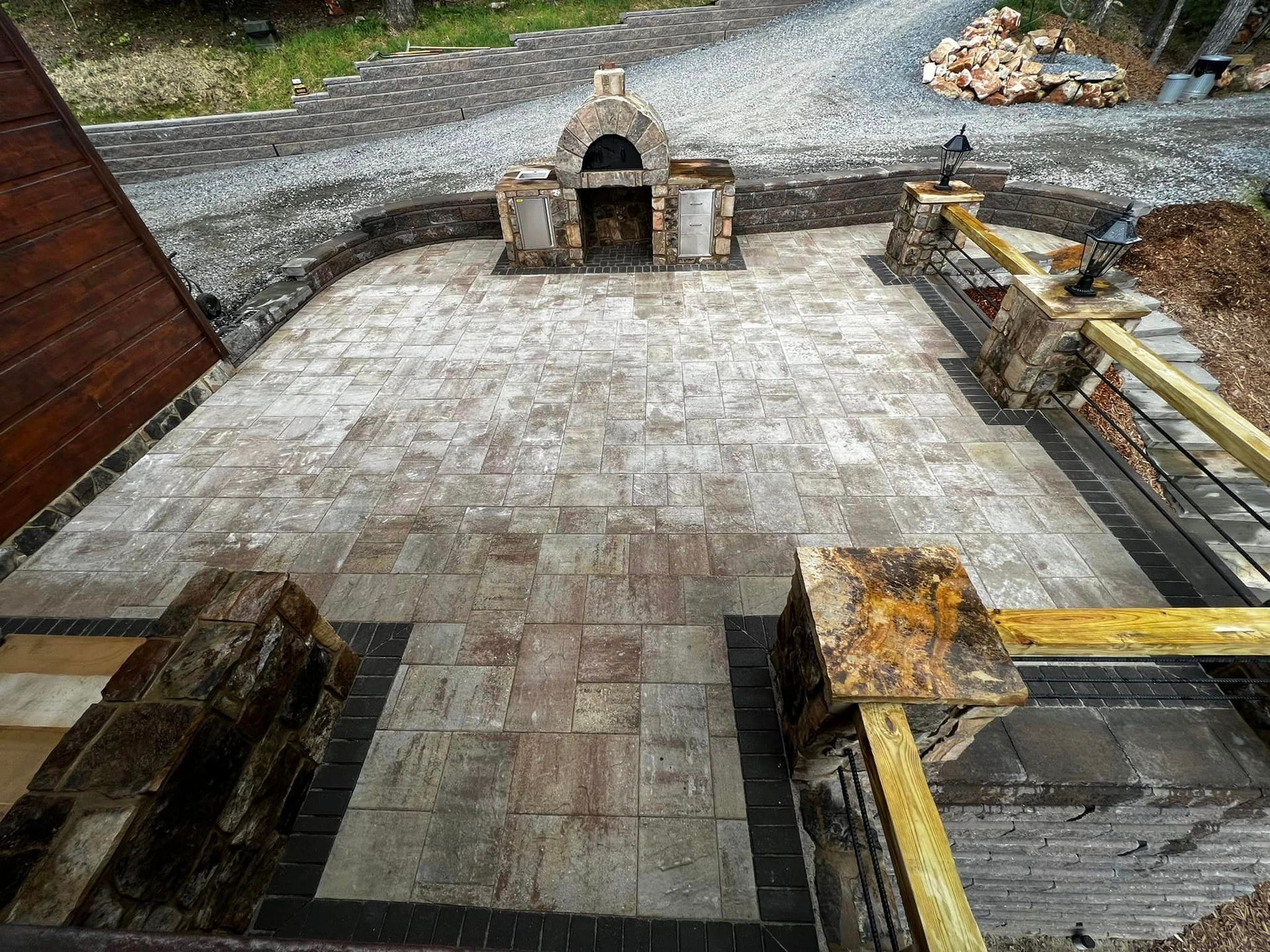 A brick patio with a fireplace in the middle of it