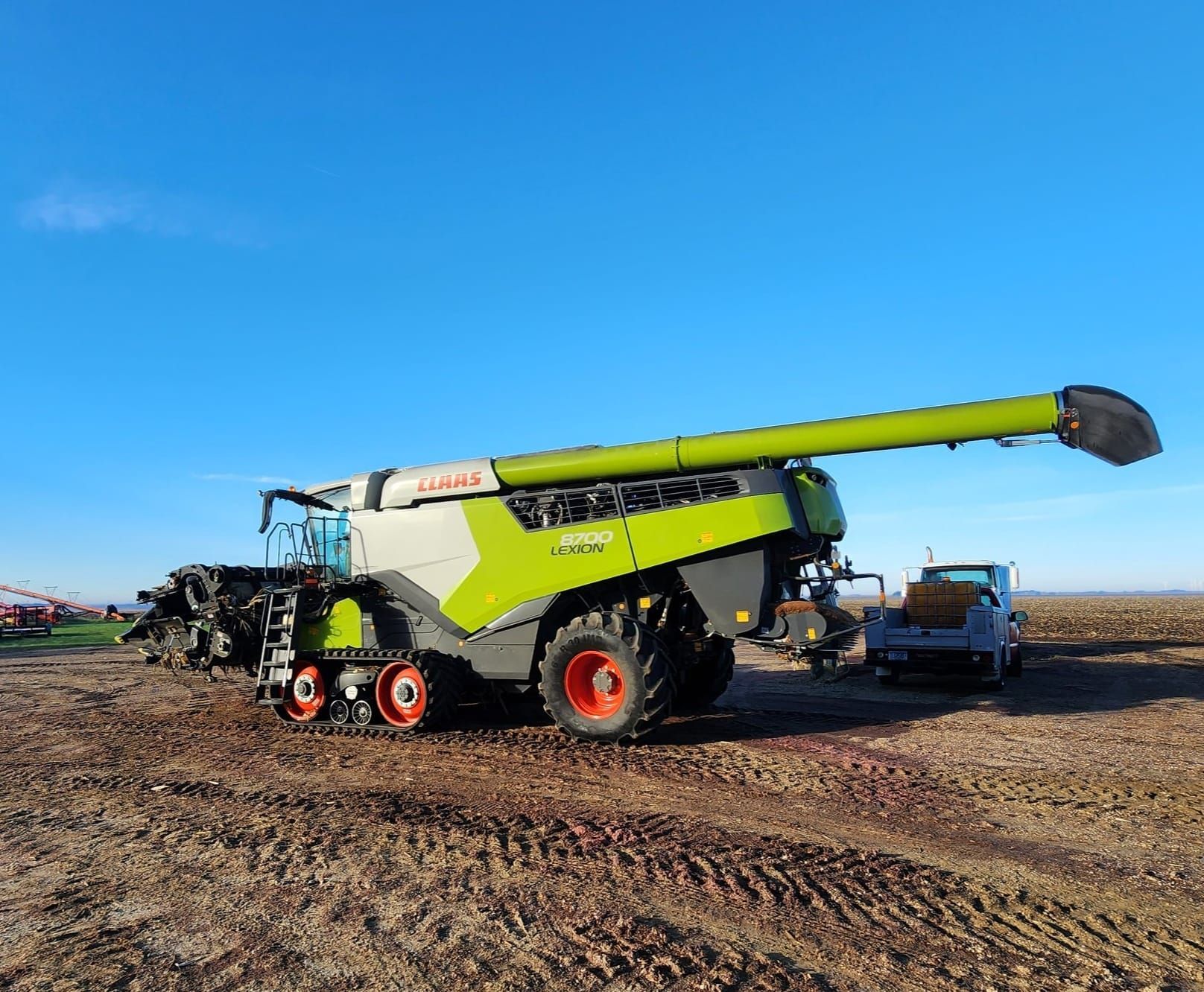 A combine harvester is parked in a dirt field.