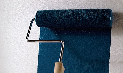 painting a wall with a paint roller