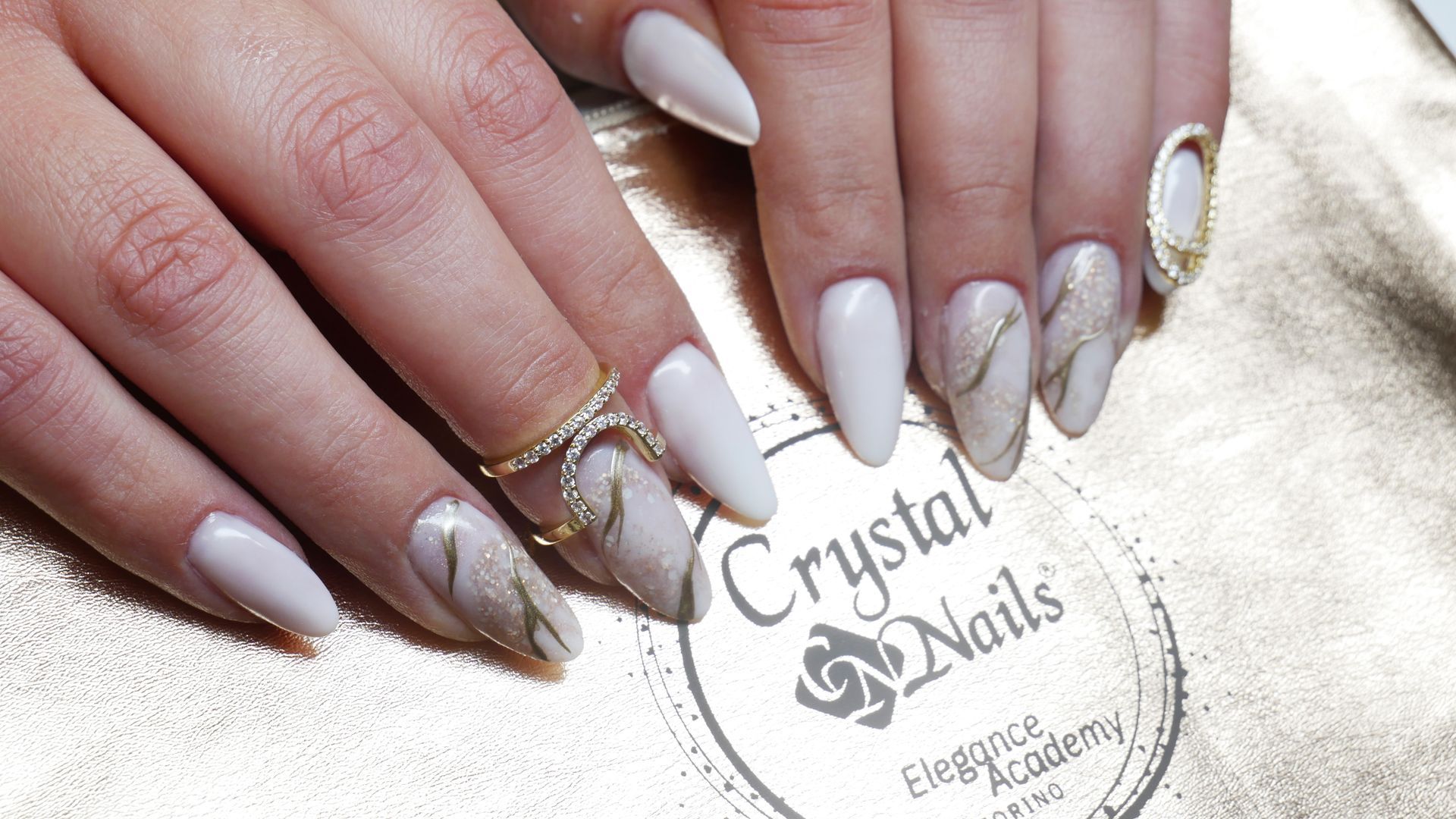 un primo piano delle mani di una donna con unghie bianche e un anello .