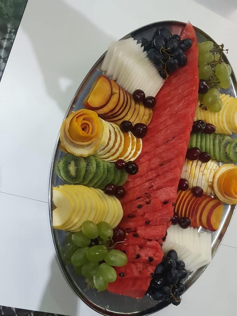 Piatto di frutta con anguria, uva, kiwi, fette d'arancia e melone.