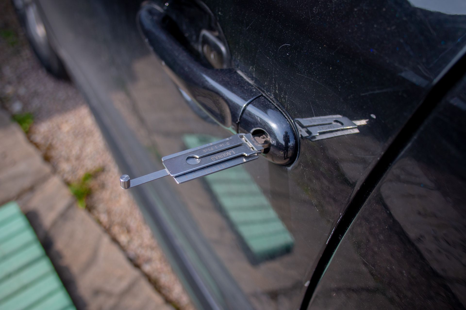 A lockpick tool being used to unlock a car door.