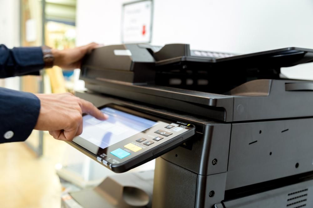 A Man is Using a Printer in an Office — Leading Edge Computers in Forster, NSW