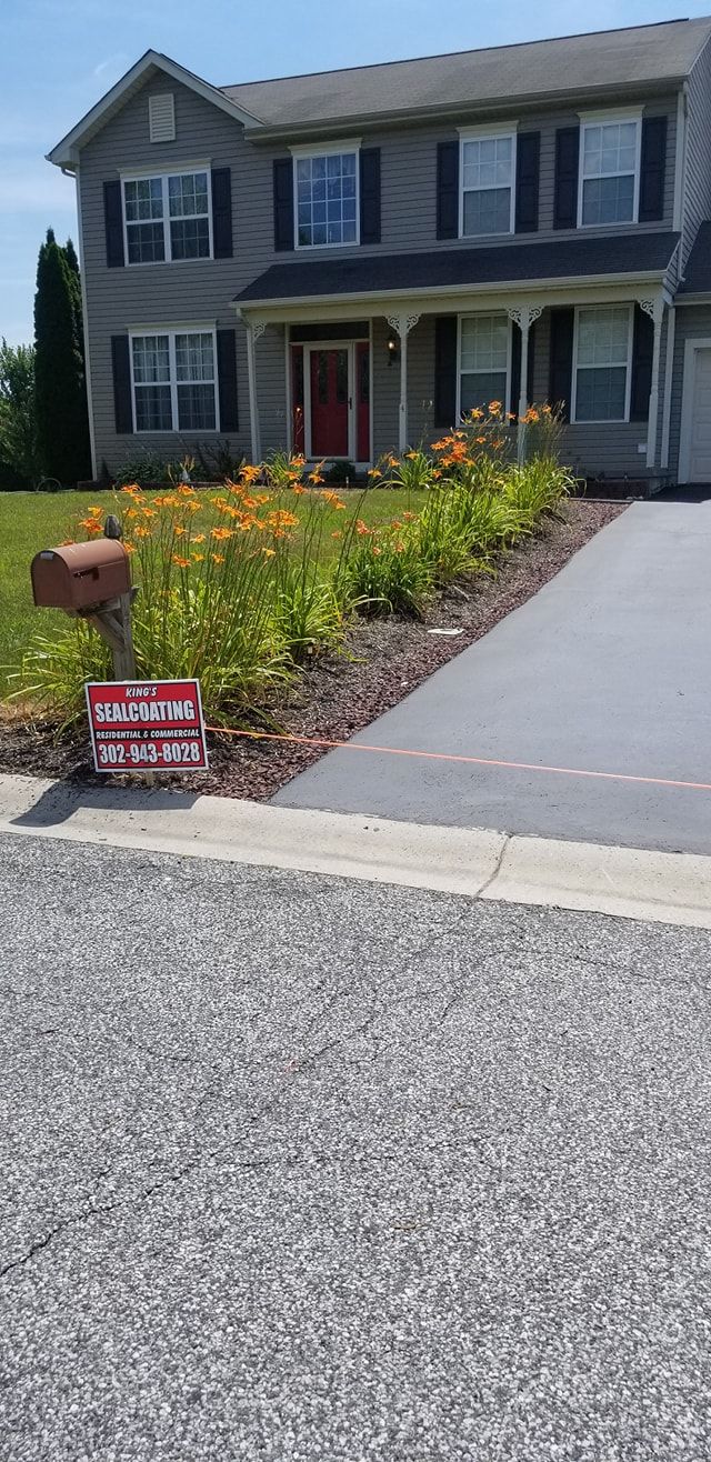 A two-story gray house with orange flowers in front. A 