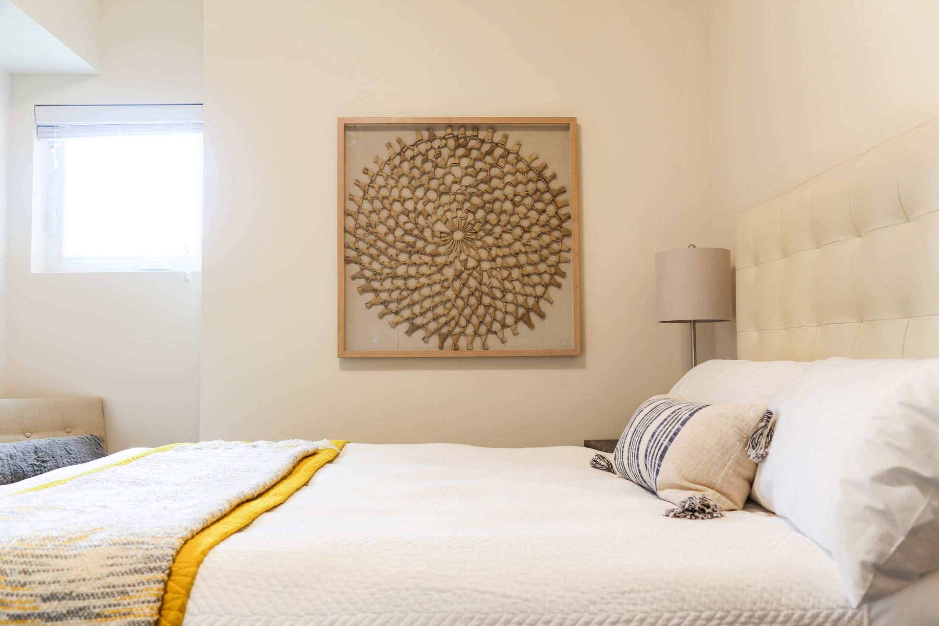 A bedroom with a large bed and a painting on the wall above it.
