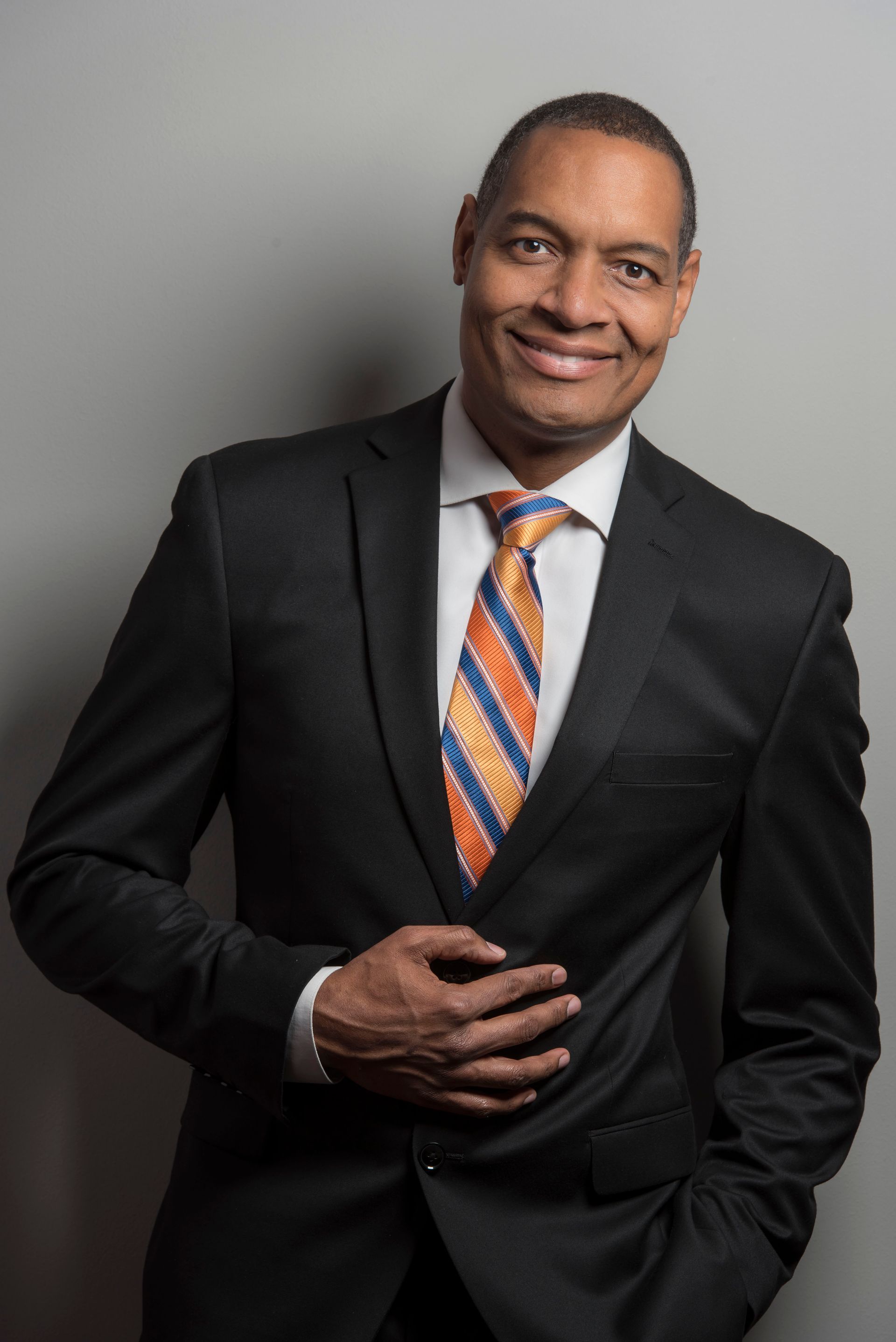 A man in a suit and tie with his hands in his pockets