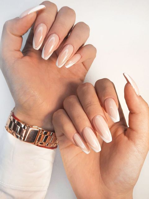 A woman 's hands with long nails and a watch on her wrist.