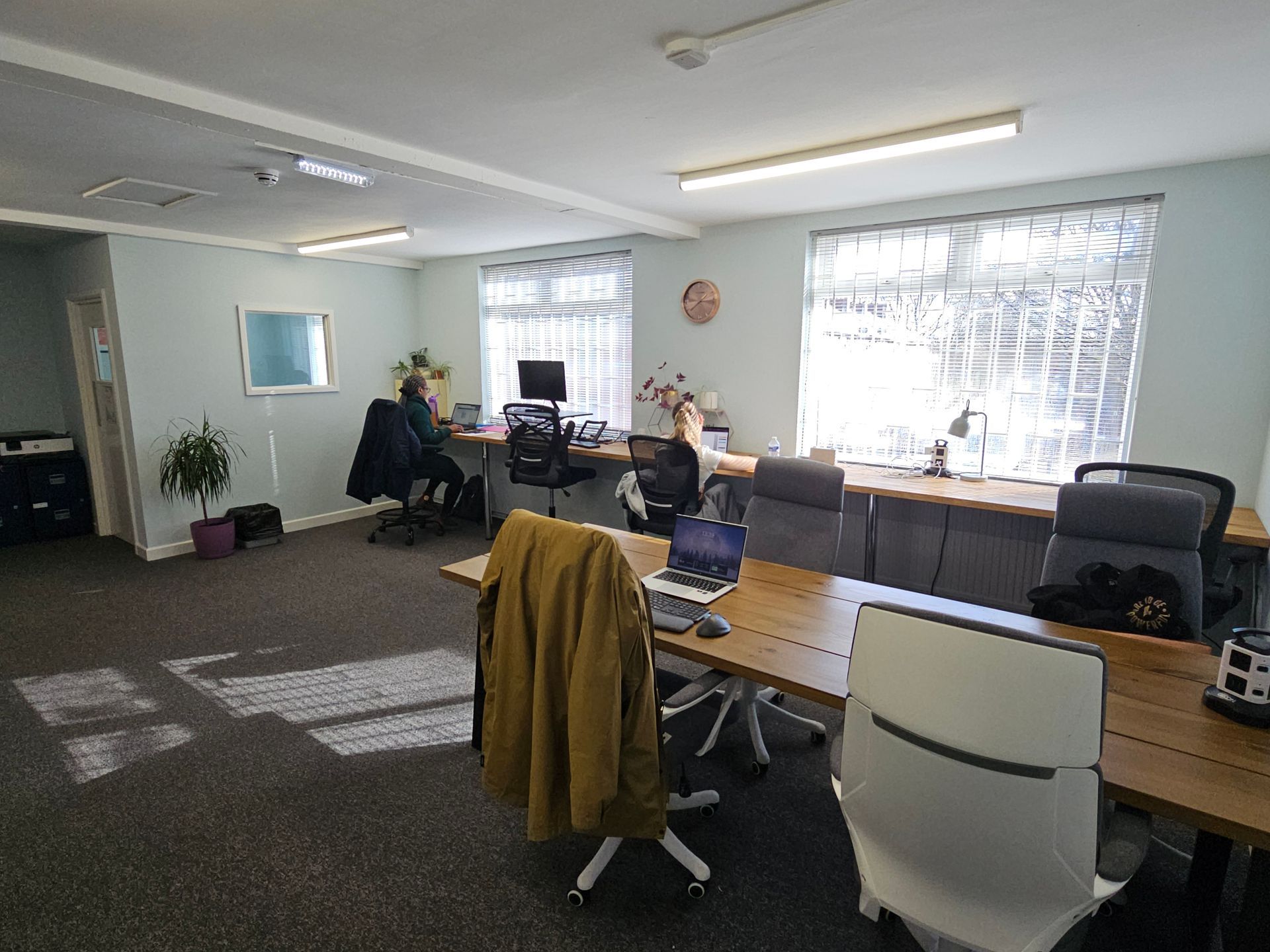 A group of people are sitting at desks in an office.