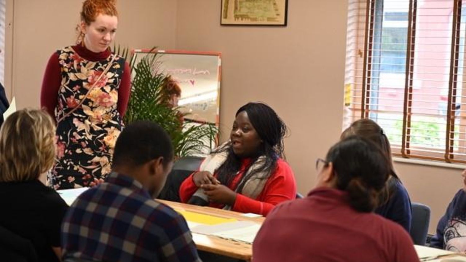 A group of people are sitting around a table in a room.