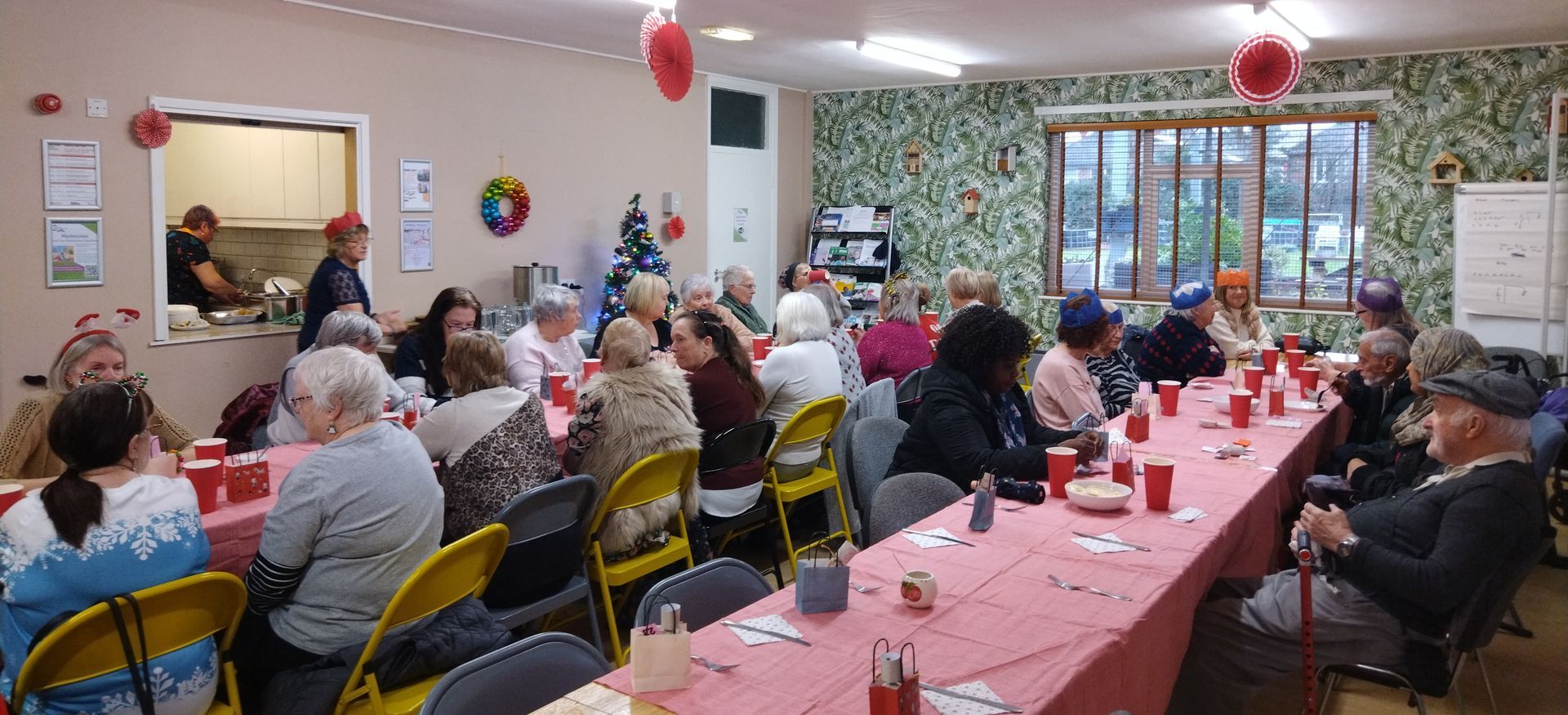 A group of people are sitting at long tables in a room.