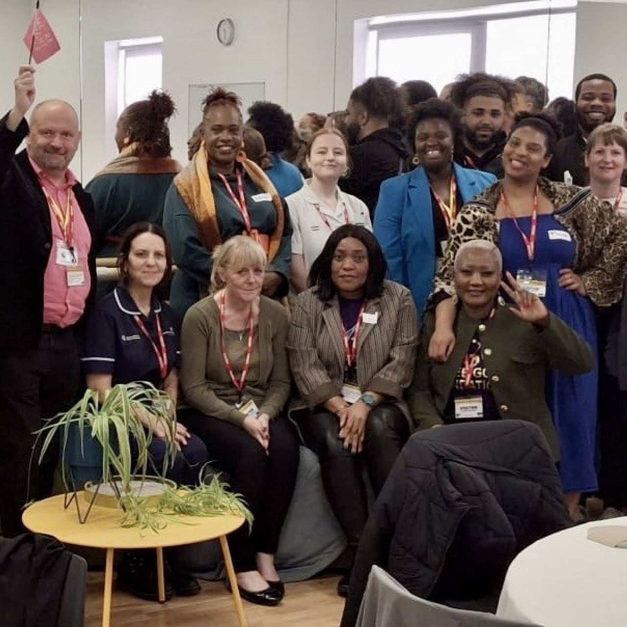 A group of people posing for a picture with a man holding a flag