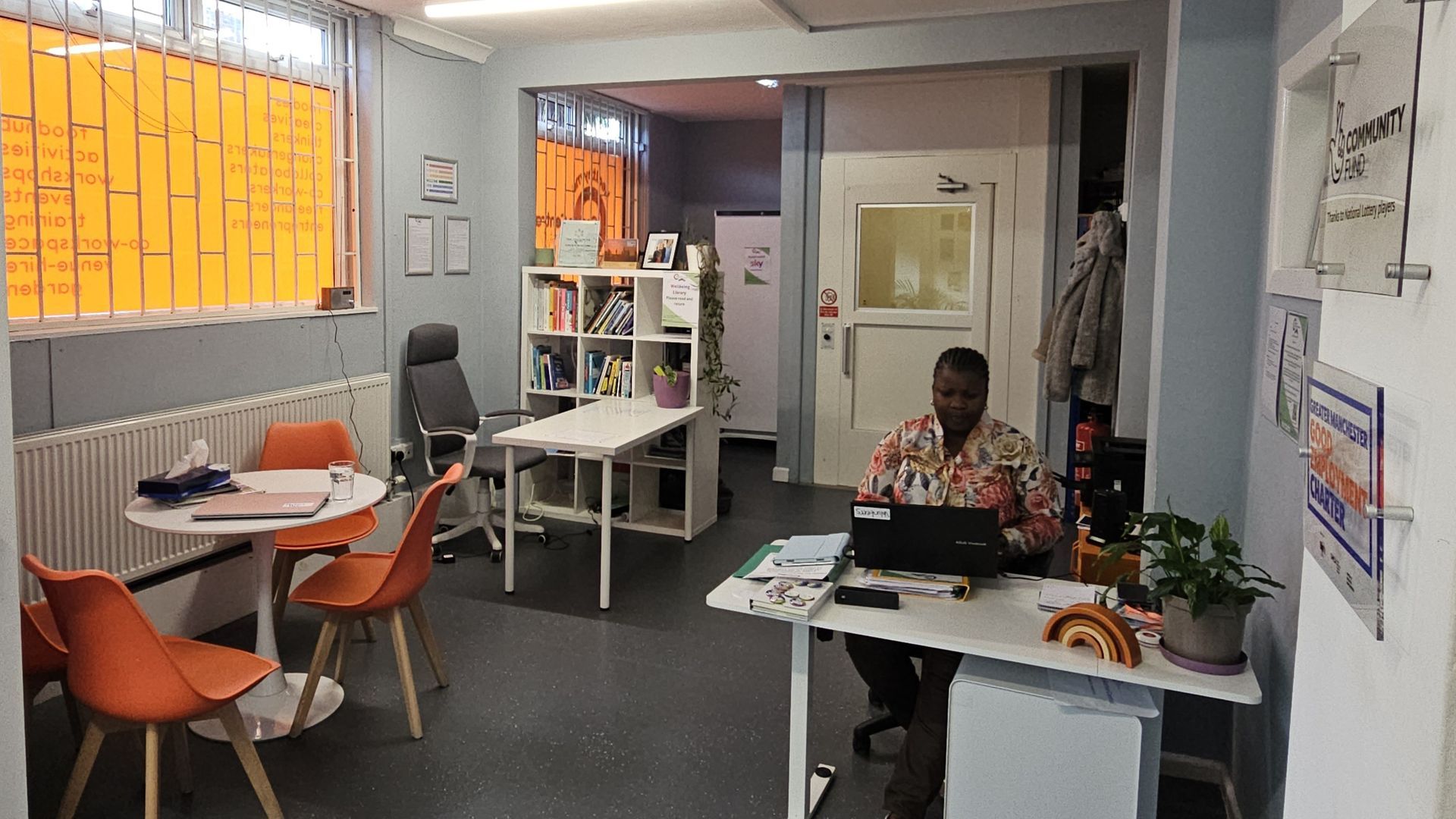 A man is sitting at a desk in an office using a laptop computer.