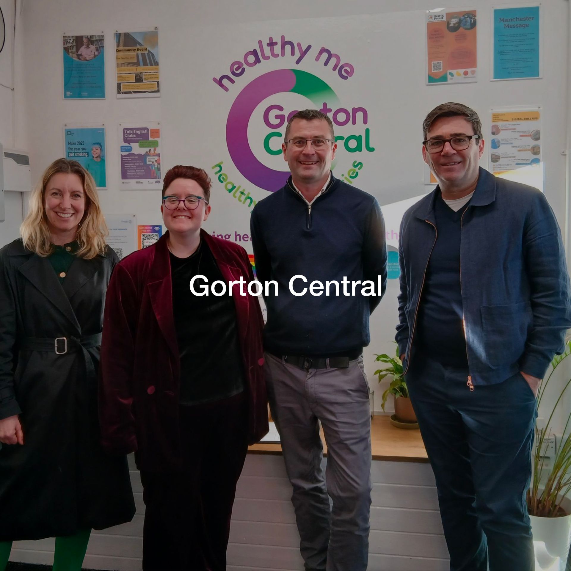 A group of people standing in front of a sign that says gorton central