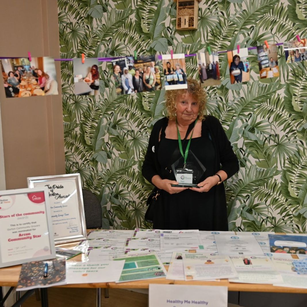 A woman stands behind a table with a sign that says healthy life reading