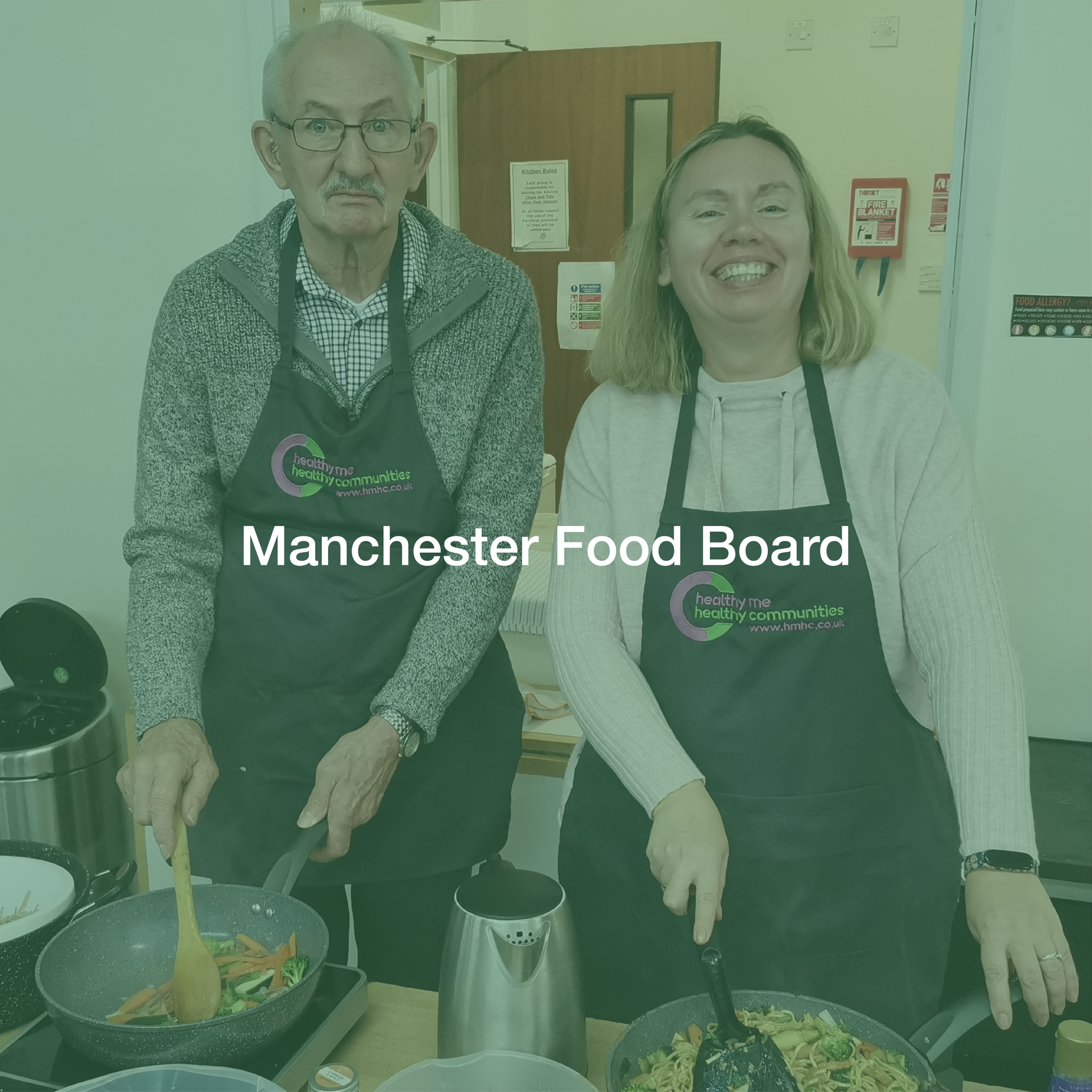 A man and a woman are cooking in a kitchen with the words manchester food board above them