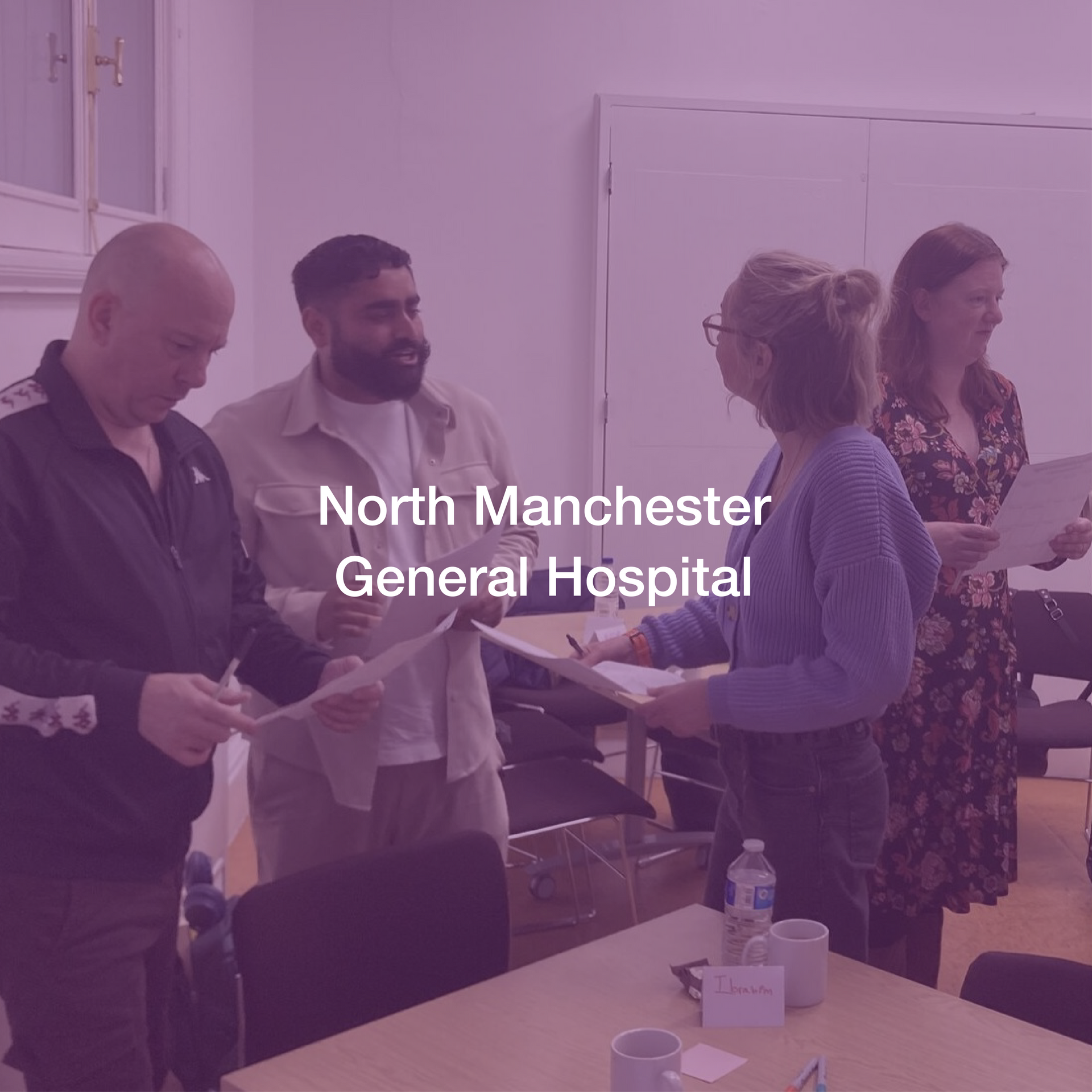 A group of people are standing around a table in a room.