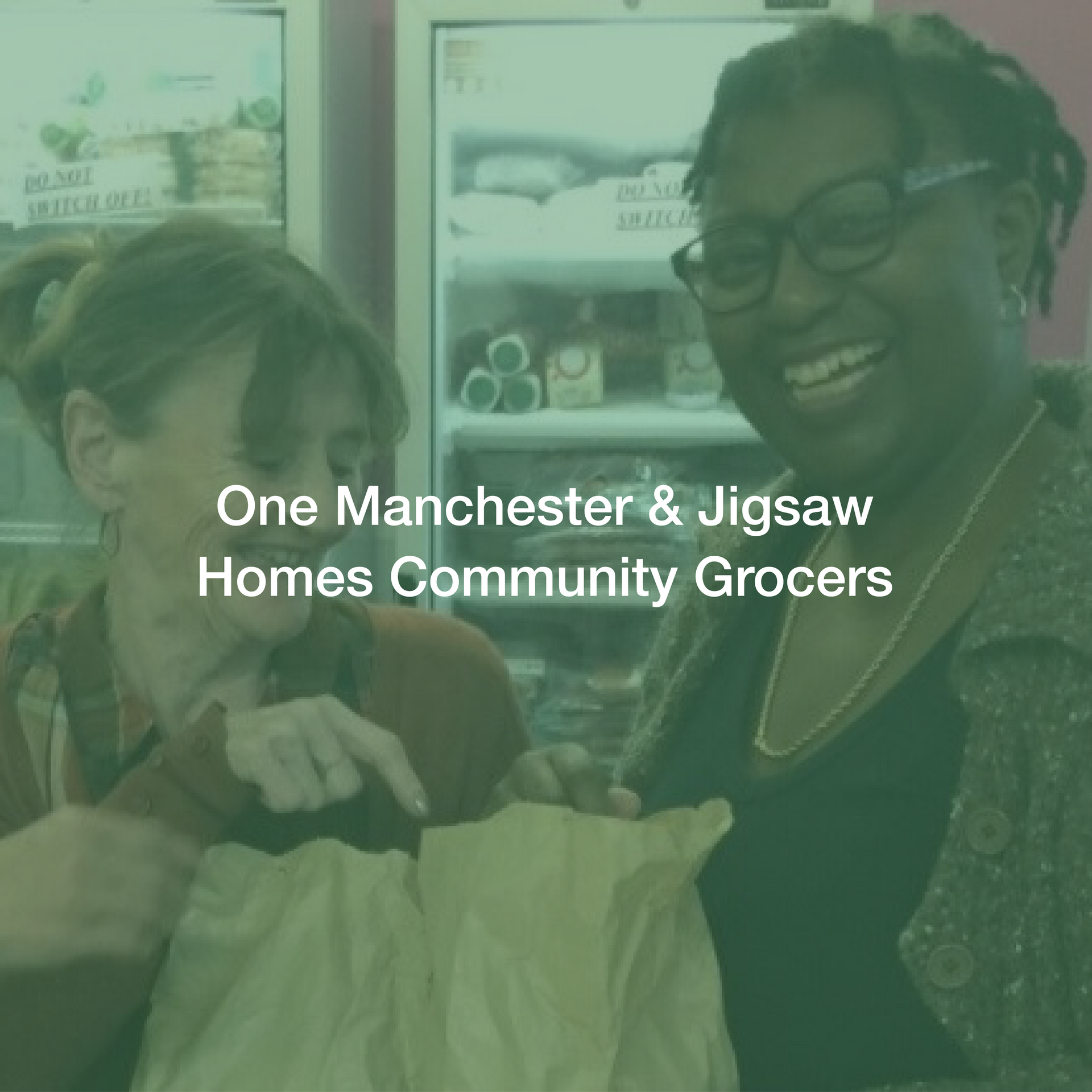 Two women are standing next to each other in front of a refrigerator.
